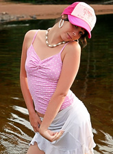 Ariel Rebel posing in her cute pink shirt and white skirt at the local lake.